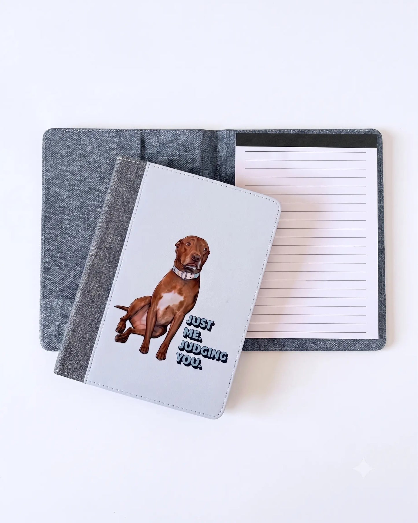 Opie reusable notepad portfolio open showing interior pocket and lined notepad, white faux leather cover with Just Me. Judging You. pit bull design leaning against it