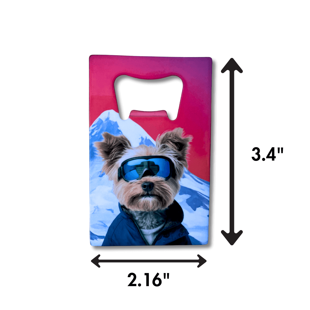 Yorkie bottle opener (sunset red behind a snowy mountain and dog wearing ski goggles. Arrows show size measurements.