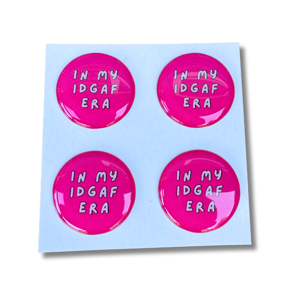 Bright pink domed sassy stickers reading “In My IDGAF Era” in white lettering, set of four on a white backing.