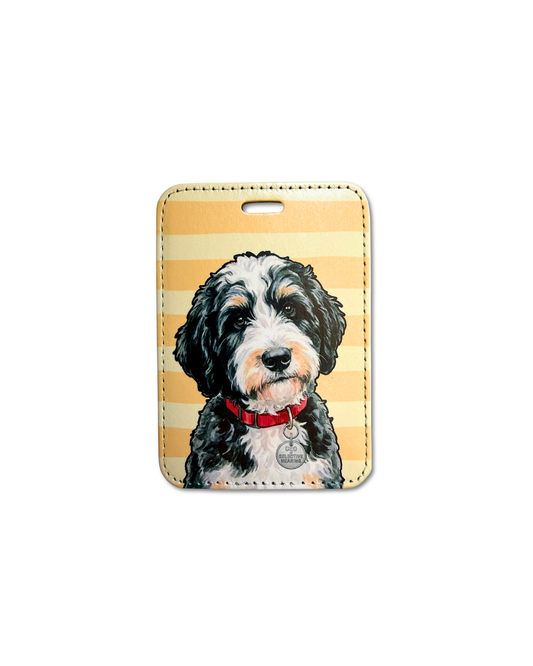 bernedoodle luggage tag featuring a fluffy black white and tan bernedoodle dog on a warm striped background