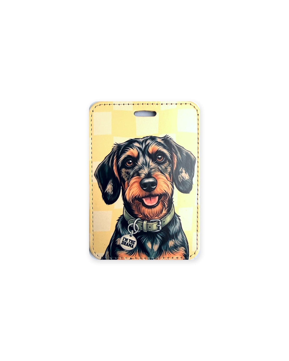 Black and tan wirehaired dachshund luggage tag with an original design of a doxie wearing a sage green collar and a round charm that reads "I'm the Drama", on a soft yellow checkered background. Faux leather luggage tag with stitched edges and a slot at the top.
