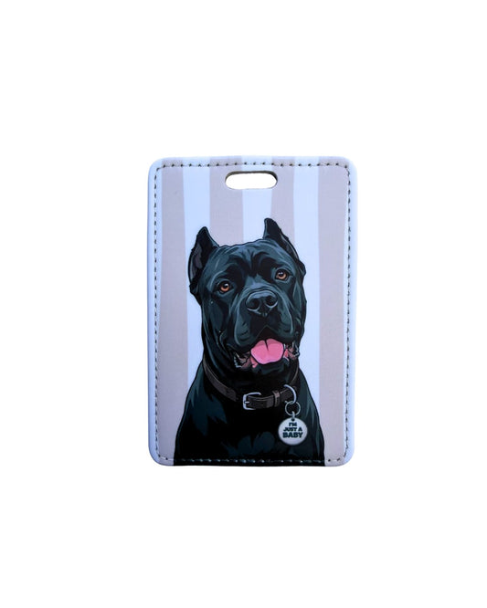 black cane corso luggage tag flat lay on white background showing muscular black Cane Corso with pink tongue and I'M JUST A BABY round collar tag on taupe and white vertical striped faux leather tag