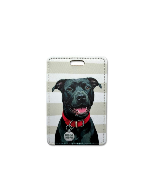 black pitbull luggage tag flat lay showing smiling black Pitbull with red collar and HOUSE HIPPO round collar tag on taupe and white horizontal striped faux leather travel tag
