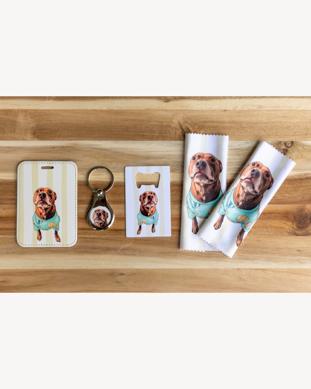 custom dog gift box flat lay showing personalized luggage tag keychain bottle opener and lens cloths on a wood surface