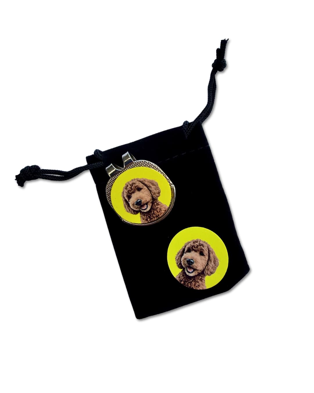 custom golf ball marker set; a silver hat clip with a custom brown dog illustration on a yellow disc and a second matching disc on top of a black velveteen pouch.