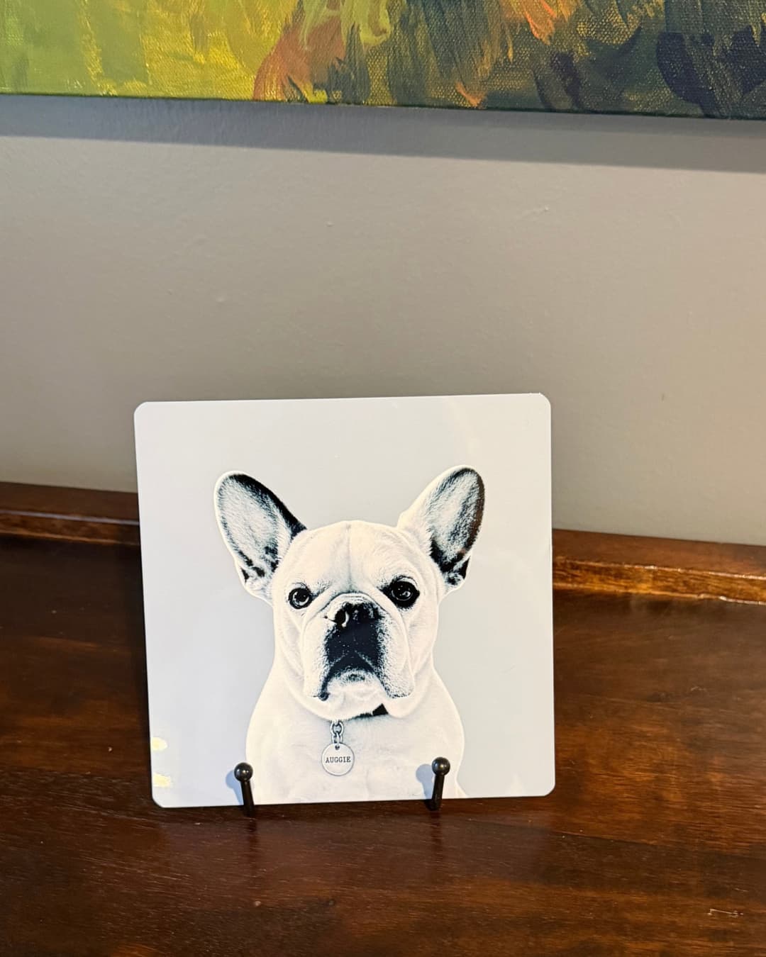 Custom pet portrait aluminum metal photo tile shown on a wood table with black metal easel.