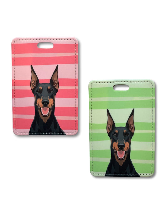 Two doberman pinscher travel tags; a dog illustration on a pink and green striped background