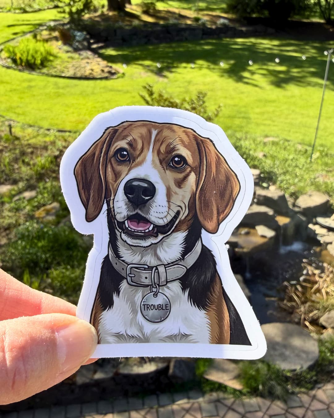 funny beagle sticker beagle dog humor sticker held between fingers outdoors with yard background