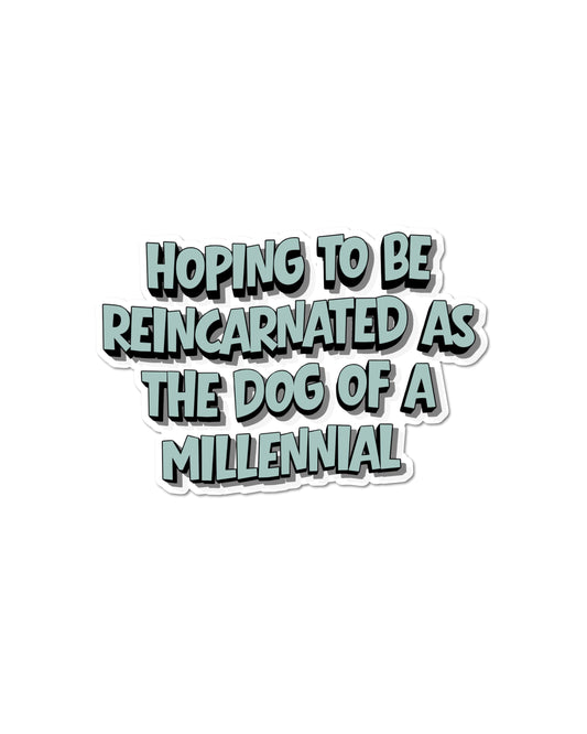 Funny millennial dog parent sticker with blue-gray lettering on a white background that reads 'Hoping to be reincarnated as the dog of a millennial.'