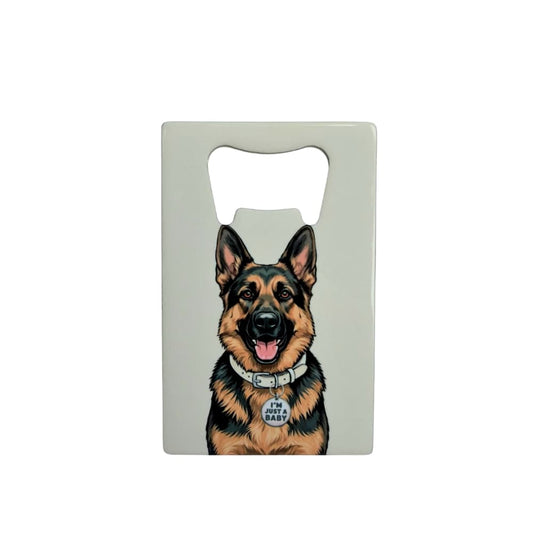 German Shepherd bottle opener; a flat stainless steel bottle opener featuring a GSD with an I'm Just A Baby collar tag against a light gray background.