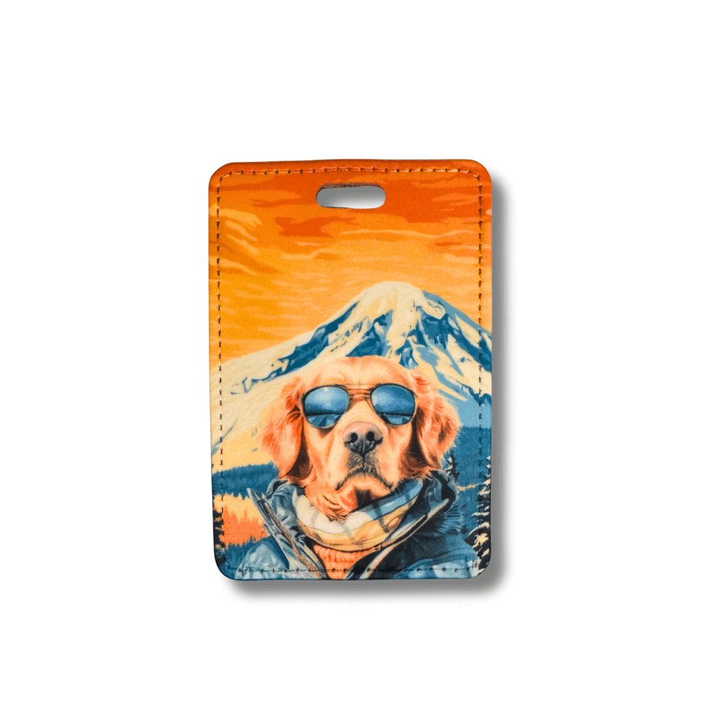 Golden Retriever luggage tag. Dog in in sunglasses and parka in front of mountain scene. Orange sunset sky.