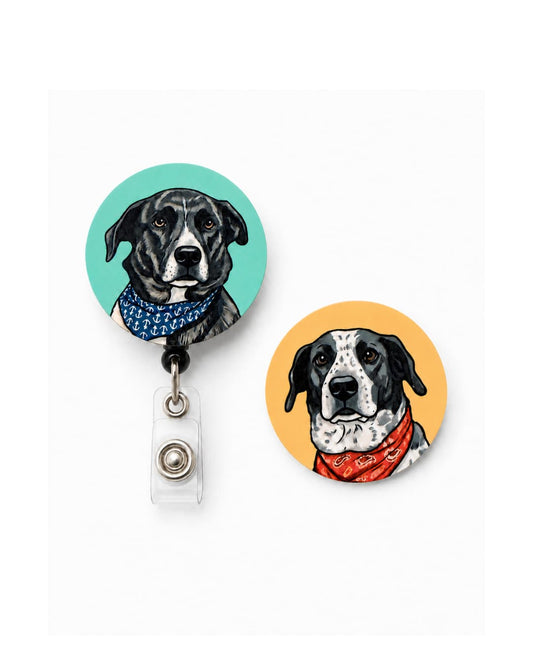 Interchangeable custom pet badge reel set with two discs, black dog with navy anchor bandana on teal disc attached to reel and black and white dog with red bandana on orange disc