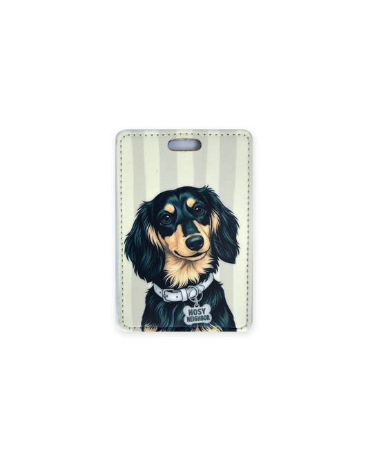 Long haired black and tan dachshund luggage tag with an original design of a doxie wearing a white collar and a bone-shaped charm that reads "Nosy Neighbor", on gray and cream stripes. Faux leather luggage tag with stitched edges and a slot at the top.