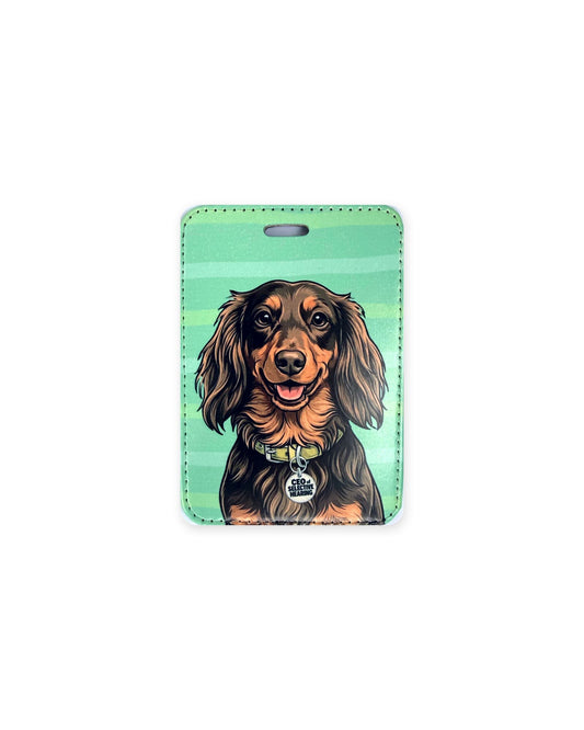 Long haired chocolate and tan dachshund luggage tag with an original design of a doxie wearing a yellow collar and a round charm that reads "CEO of Selective Hearing", on a green background. Faux leather luggage tag with stitched edges and a slot at the top.