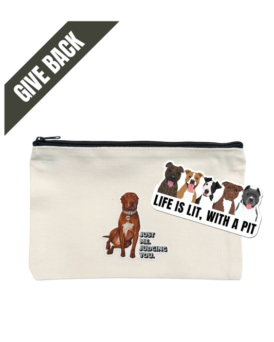 Opie zipper pouch: Beige canvas bag with top zipper. Design of Opie the pit bull with caption "Just me. Judging you." on front. White background. "Life is Lit with a Pit" 3" sticker (5 illustrated pit bulls on white sticker with black font) on top of pouch. Dark gray banner in top corner reads GIVE BACK