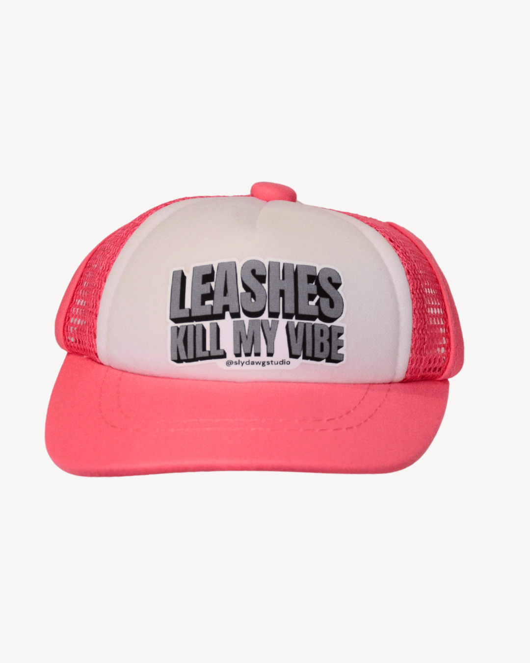 pink and white dog hat with saying on it.  text 'LEASHES KILL MY VIBE' on a white background