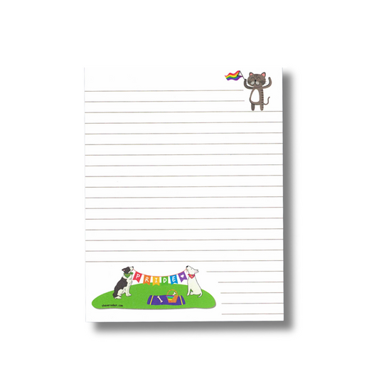 lined notepad. Pride themed. Cat in upper right corner waving Pride flag. Dogs on bottom of page are sitting on grass having a picnic. They are holding a string banner that spells PRIDE.