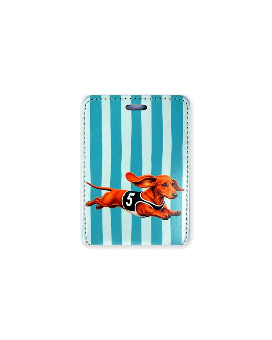 Red racing dachshund luggage tag showing an original design of a red smooth coat doxie mid-sprint with ears flying, wearing a black racing vest with the number 5, on teal and white stripes. Faux leather luggage tag with stitched edges and a slot at the top.