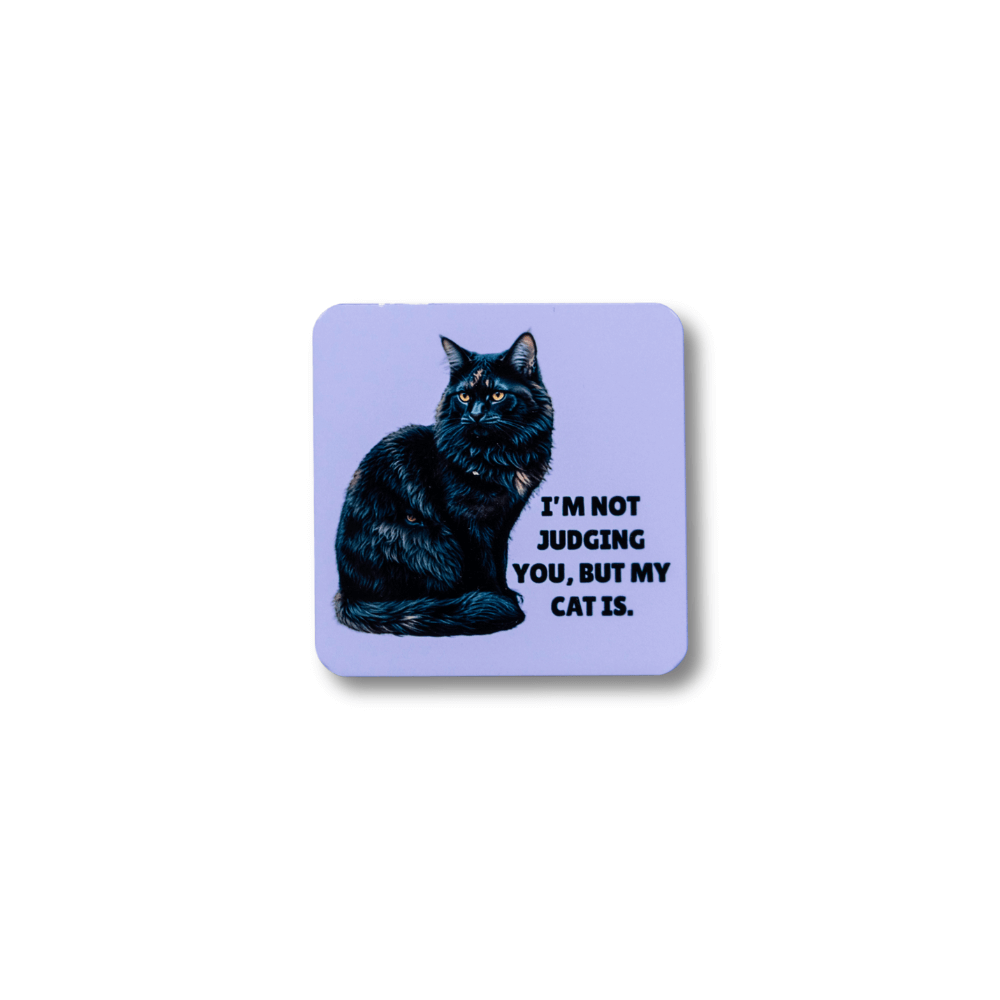 A square purple funny tortie cat magnet featuring a long-haired tortoiseshell cat and the text "I'm not judging you, but my cat is." Lavender magnet on white background.